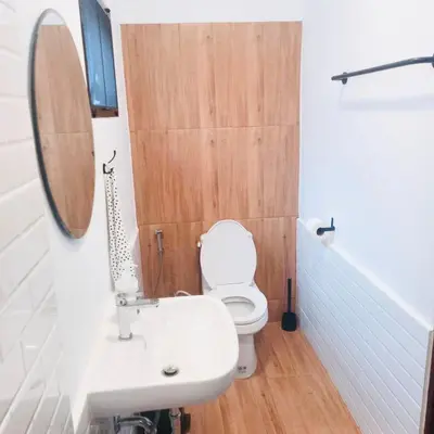 a bathroom with a toilet and a sink and a mirror at SLEEP SLEEP SUANPHAK Homestay in Ban Khlong Bang Sai