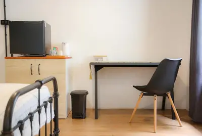a desk with a chair and a television in a bedroom at SLEEP SLEEP SUANPHAK Homestay in Ban Khlong Bang Sai
