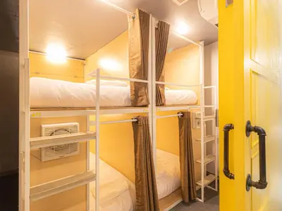 a room with three bunk beds in a room at Khao San Social Capsule Hostel in Bangkok