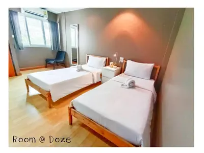 a room with two beds and a chair at Room@Doze in Nonthaburi