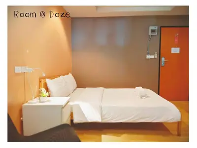 a room with a bed and a table and a door at Room@Doze in Nonthaburi
