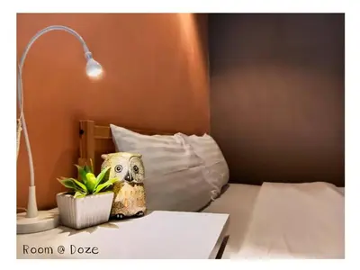 a room with a bed with a lamp and a plant at Room@Doze in Nonthaburi