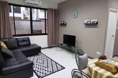 a living room with a couch and a tv at 8FINITE House in Bang Su