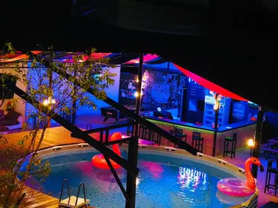 a house with a swimming pool at night at Wild Ones Hostel in Bangkok
