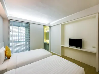 a hotel room with two beds and a flat screen tv at Kitzio House Hotel Huai Kwang in Bangkok