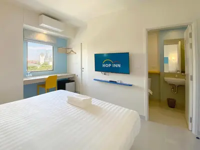 a bedroom with a bed and a tv on a wall at HOP INN Bangkok Bangna in Bangkok