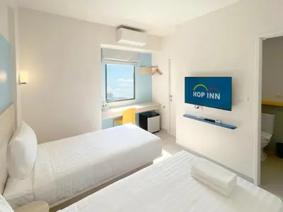 a hotel room with two beds and a tv at HOP INN Bangkok Bangna in Bangkok