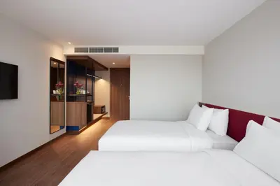 two beds in a room with a tv at Centara Life Hotel Bangkok Phra Nakhon in Bangkok
