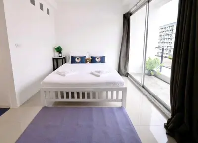 a white bedroom with a bed and a large window at RQ Bangkok Sukhumvit 50 by Collection O in Amphoe Phra Khanong