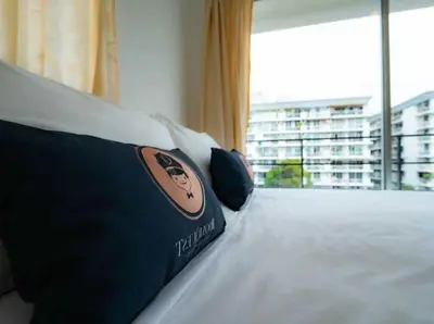 a bed in a hotel room with a picture of a cat on it at RQ Bangkok Sukhumvit 50 by Collection O in Amphoe Phra Khanong