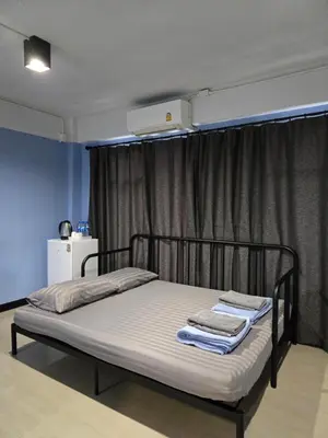 a bed with two towels on it in a room at HOUSEMODE - BAANYAI @ Wongwian Yai in Bangkok