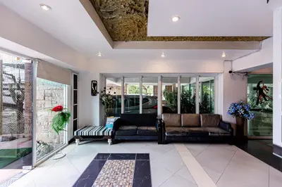 a living room with a couch and windows at Latin Garden Hotel in Bangkok