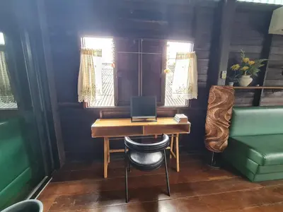 a desk with a computer on it in a room at Non House Bangkok บ้านนอนโฮสเทล in Bangkok