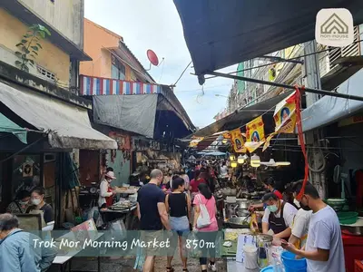 a group of people walking around a market with vendors at Non House Bangkok บ้านนอนโฮสเทล in Bangkok