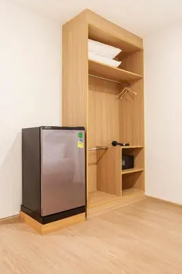 a black refrigerator in a room with a closet at TAKKA Hotel - Bangna in Bangna