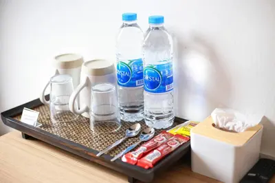 a tray with bottles of water and other items on a table at TAKKA Hotel - Bangna in Bangna