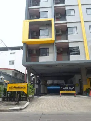 a building with a parking garage in front of it at A23 residence in Bangkok