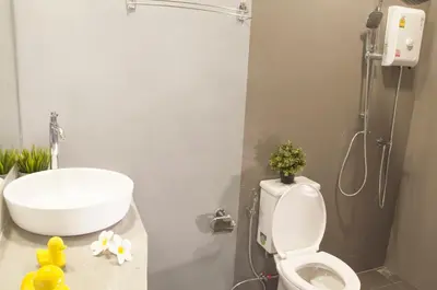 a bathroom with a white sink and a toilet at A23 residence in Bangkok