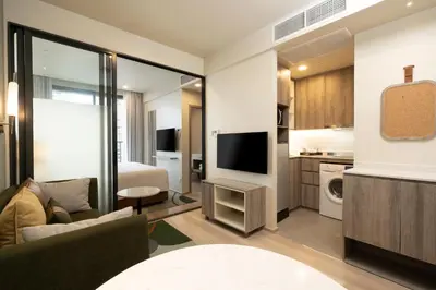 a living room with a couch and a television in a room at Staybridge Suites Bangkok Sukhumvit by IHG in Bangkok