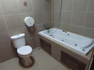 a bathroom with a toilet and a bath tub at Flourish Apartments in Bangkok
