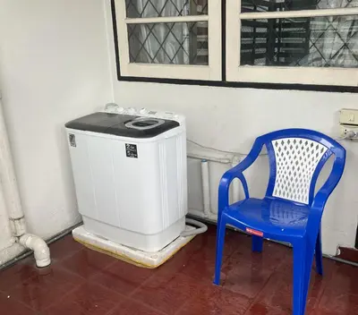a blue chair sitting next to a small heater at Flourish Apartments in Bangkok
