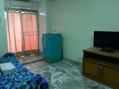 a room with a blue refrigerator and a tv at S.K. Residence in Bangkok