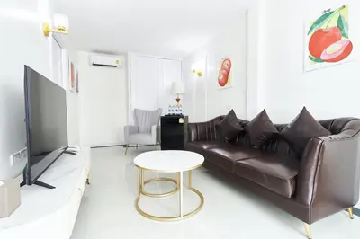 a living room with a leather couch and a table at Rose Apple Hotel in Bangkok