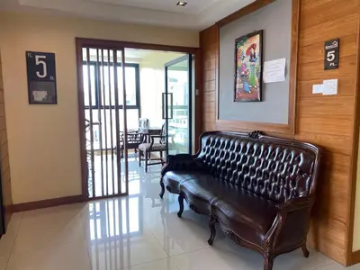 a leather couch in a waiting room with a number six at L18 residence แอลสิบแปด เรสซิเดนซ์ in Ban Zong Katiam