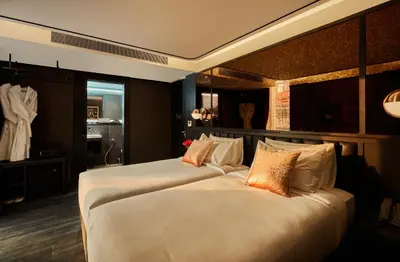 two beds in a hotel room with a room with a mannequin at The Gravitique Hotel Khaosan in Bangkok