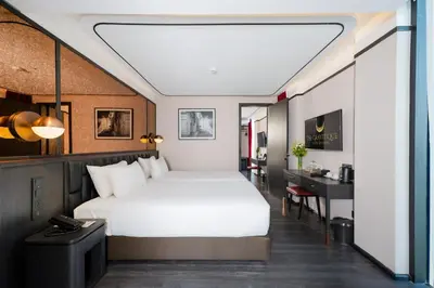 a bedroom with a white bed and a desk at The Gravitique Hotel Khaosan in Bangkok