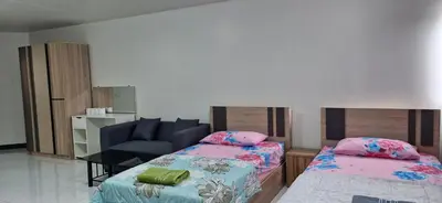 a living room with two beds and a couch at ห้องพักรายวัน เมืองทองธานี เรือนศรีตรัง in Ban Bang Phang