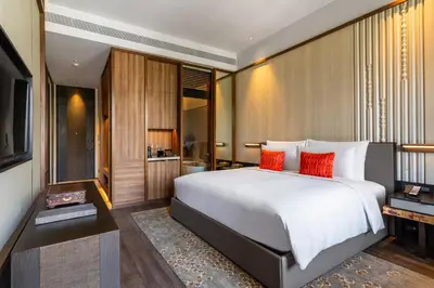 a bedroom with a large white bed with red pillows at Villa Deva Resort & Hotel Bangkok in Bangkok