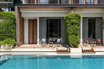 a house with a swimming pool next to a house at Villa Deva Resort & Hotel Bangkok in Bangkok
