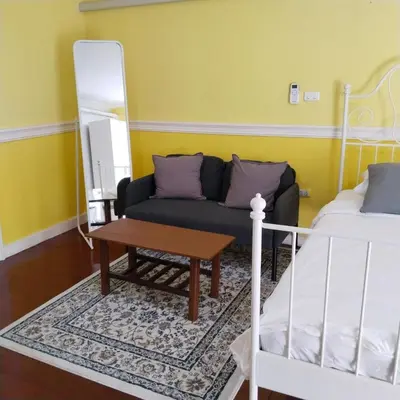 a living room with a couch and a table at Aran Colonial House & Cafe Ngamwongwan in Ban Bang Khen (1)