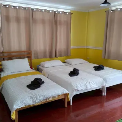 two beds with hats on top of them in a room at Aran Colonial House & Cafe Ngamwongwan in Ban Bang Khen (1)