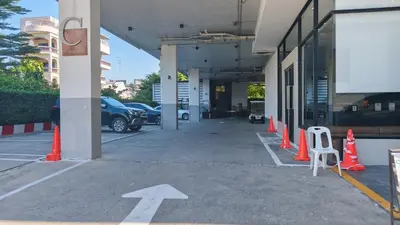 an empty parking lot with orange cones and a white arrow at C Hotel Bangna in Bangkok