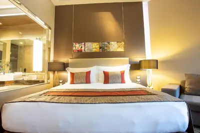 a bedroom with a large bed with two lamps at Graceland Bangkok by Grace Hotel - SHA Extra Plus in Bangkok