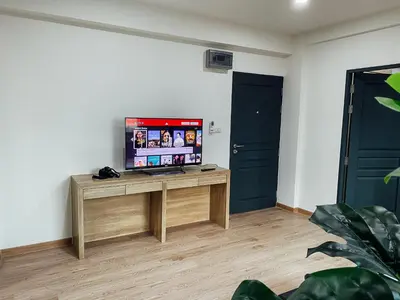 a living room with a television on a wooden table at GP House Bangkok - Sukhumvit Onnut BTS Skytrain in Bangkok
