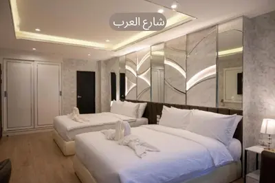 a hotel room with two beds with white sheets at Masa Hotel فندق الماسة شارع العرب in Bangkok