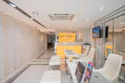 a waiting room with white chairs and a table at Masa Hotel فندق الماسة شارع العرب in Bangkok