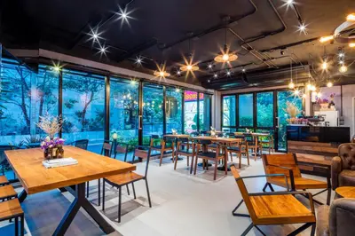 a restaurant with tables and chairs and windows at Livotel Hotel Lat Phrao Bangkok in Bangkok
