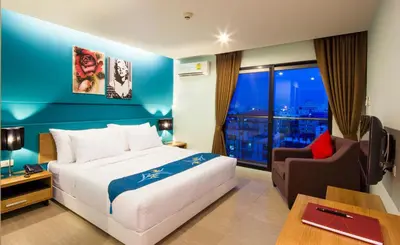 a hotel room with a bed and a chair at Livotel Hotel Lat Phrao Bangkok in Bangkok