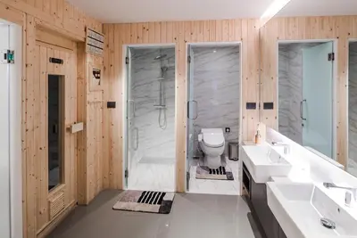 a bathroom with two sinks and a shower and a toilet at VOQUE Hotel & Serviced Residence Sukhumvit 51 in Bangkok