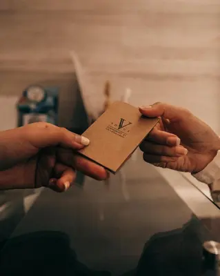 two hands holding a card with the letter h on it at VOQUE Hotel & Serviced Residence Sukhumvit 51 in Bangkok