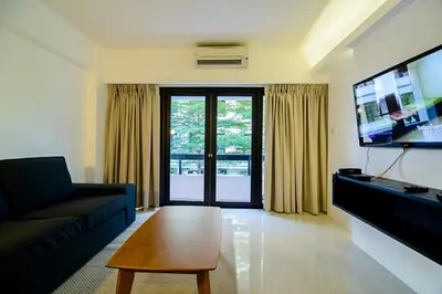 a living room with a couch and a tv at UMA Residence in Bangkok