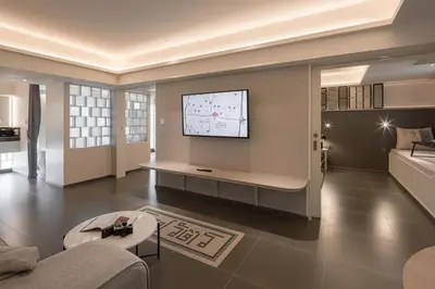 a living room with a tv on a wall at YANH Ratchawat Hotel in Bangkok