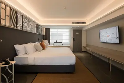 a bedroom with a large bed and a tv at YANH Ratchawat Hotel in Bangkok