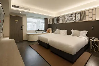 a hotel room with two beds and a bath tub at YANH Ratchawat Hotel in Bangkok