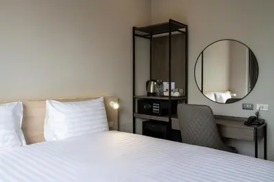 a hotel room with a bed and a mirror at fyn park hotel in Makkasan