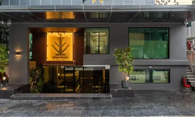 a building with a plant on the front of it at City Park Hotel Bangkok Pratunam by PCL in Bangkok